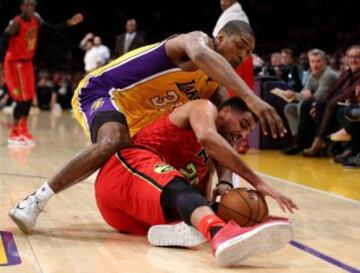 Thabo Sefolosha y Metta World Peace luchan por el balón.