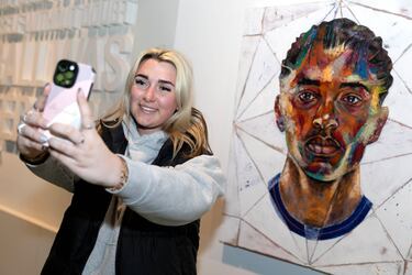 Una aficionada se hace un selfie junto al retrato que un artista local ha realizado de Bellingham con la selección inglesa.