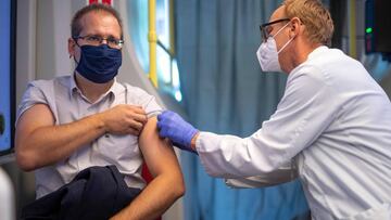 A man receives a flu vaccine inside the mobile vaccination station "Impfbim" located in a tram in Vienna, Austria, on October 1, 2020. - The city is encouraging residents to get the vaccine in order to reduce any coronavirus-related pressure on the health system over the winter. (Photo by JOE KLAMAR / AFP)
