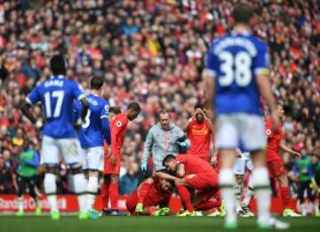 Emre Can of Liverpool (C) receives treatment from the medical team during the Premier League match between Liverpool and Everton at Anfield on April 1, 2017 in Liverpool, England.