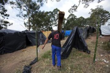 Un hombre carga madera para construir su vivienda improvisada en una área que fue ocupada por Integrantes del Movimiento de los Trabajadores Sin Techo (MTST) el pasado sábado situada a unos 4 kilómetros del estadio Arena Corinthians de Sao Paulo, una de las doce sedes del Mundial Brasil 2014 y que recibirá seis partidos del evento deportivo, entre ellos el inaugural del 12 de junio. De acuerdo con el movimiento, las familias que ocuparon el terreno, abandonado desde hace más de 20 años, vivían en áreas "de riesgo", "en favelas o sin condiciones para pagar el alquiler por culpa de la especulación inmobiliaria en la región, resultado de la construcción del estadio de apertura del Mundial".