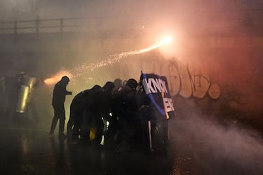 Manifestantes lanzan fuegos artificiales contra la policía durante una protesta contra el impacto ambiental, económico y social de los Juegos Olímpicos de Invierno de Milán-Cortina 2026.