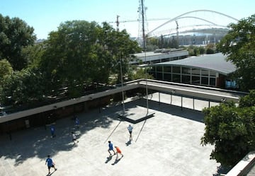Varios niños juegan al fútbol en el patio del colegio.