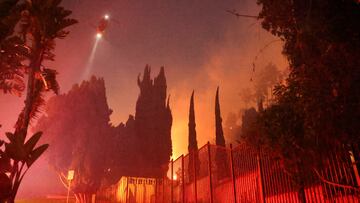 A helicopter flies, as smoke rises from the Sunset Fire in the hills overlooking the Hollywood neighborhood of Los Angeles, California, U.S. January 8, 2025. REUTERS/David Swanson
