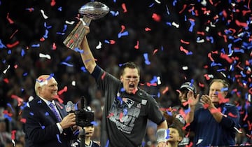 Tom Brady of the New England Patriots holding the Vince Lombardi Trophy as Head coach Bill Belichick looks on