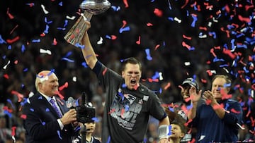 Tom Brady of the New England Patriots holding the Vince Lombardi Trophy as Head coach Bill Belichick looks on