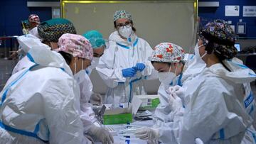 Health workers get ready to perform PCR tests to passengers in the arrival area of Cagliari's airport, on March 15, 2021. - Sardinia is the only Italian region designated as low-risk and escaping Covid-19 restrictions. (Photo by Alberto PIZZOLI / AFP)
