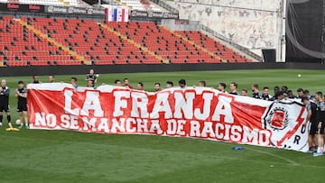 Los jugadores posan con una pancarta, como parte de las jornadas contra el racismo organizadas por la afici&oacute;n, tras el entrenamiento del s&aacute;bado.