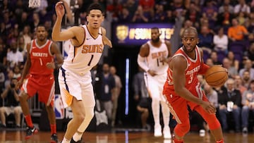 Chris Paul lleva el bal&oacute;n perseguido por Devin Booker.