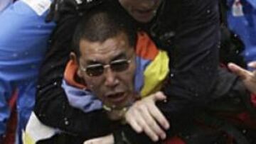 Un manifestante es reducido por la policía