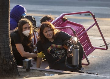 Un manifestante hace una mueca de dolor tras ser alcanzado por un proyectil "menos letal" disparado por agentes de policía durante una protesta contra las redadas federales de inmigración en el centro de Los Ángeles.