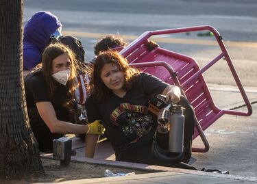 Un manifestante hace una mueca de dolor tras ser alcanzado por un proyectil "menos letal" disparado por agentes de policía durante una protesta contra las redadas federales de inmigración en el centro de Los Ángeles.