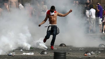 An England fan kicks a tear gas canister as fans clash with police ahead of the game against Russia later today on June 11, 2016 in Marseille, France. Football fans from around Europe have descended on France for the UEFA Euro 2016 football tournament.