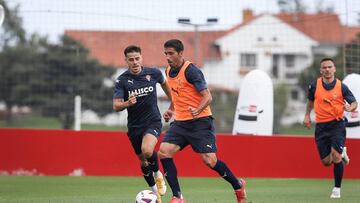 14-09-23. ENTRENAMIENTO DEL SPORTING EN MAREO. COTE CONDUCE EL BALÓN ANTE GASPAR, SEGUIDO DE CERCA POR ROQUE MESA.