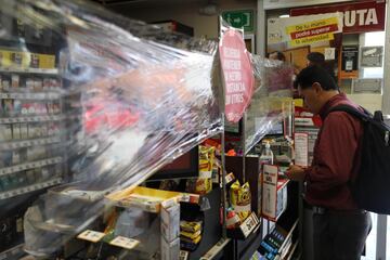 Para mantenerse abierto y a la vez cumplir con la "sana distancia", una tienda de conveniencia adopta medidas para la atención de los clientes.