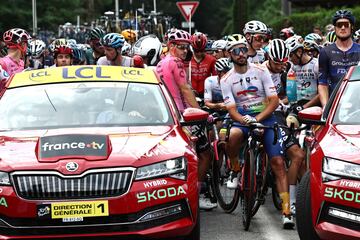 Ciclistas del pelotón espectantes tras la detención de la carrera debido al accidente masivo en el que cayeron al suelo más de 30 ciclistas.