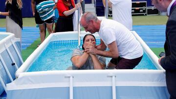 Una creyente es bautizada durante la asamblea internacional de los testigos de Jehov&aacute;, que se celebra en el estadio Wanda Metropolitano a la que asisten unos 52.000 asistentes con el objetivo de darse m&aacute;s a conocer y extender su presencia internacional. 