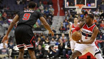 John Wall pasa a Bradley Beal (fuera de la foto) ante Rajon Rondo.