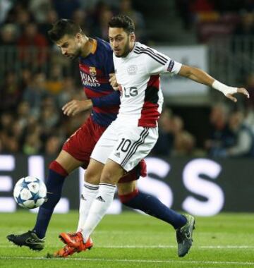 El defensa del FC Barcelona, Gerad Piqué, intenta controlar el balón ante la oposición del turco Hakan Çalhanoglu, del Bayer Leverkusen
