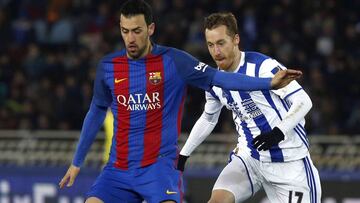 El centrocampista del F. C. Barcelona, Sergio Busquets, protege el bal&oacute;n ante el jugador de la Real Sociedad, David Zurutuza, durante el encuentro correspondiente a la ida de los cuartos de final de la Copa del Rey, que disputan esta noche en el estadio de Anoeta, en San Sebasti&aacute;n.