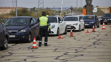 Un guardia civil de Tráfico da el alto durante un control en la carretera R5 km 20, en Madrid (España), a 26 de marzo de 2021. Un total de 4.818 efectivos de las Fuerzas y Cuerpos de Seguridad del Estado (FCSE) se desplegarán esta Semana Santa en la Comun