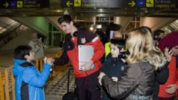 Courtois le devuelve a un aficionado su rotulador tras firmarle un guante en la llegada del equipo al aeropuerto de Bilbao.