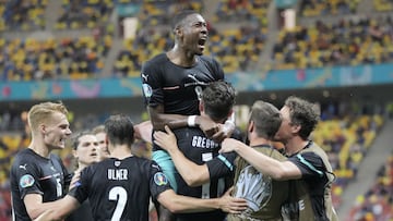 Austria's Michael Gregoritsch, center down, celebrates with teammates after scoring his side's second goal during the Euro 2020 soccer championship group C match between Austria and Northern Macedonia at the National Arena stadium in Bucharest,