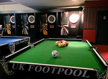 Un billar jugado con los pies. Tal cual. En lugar de tacos y bolas de billar se usan balones de fútbol. El objetivo es meter todas las bolas de tu color y terminar cerrando la partida introduciendo la bola negra.