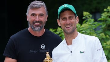 Novak Djokovic y Goran Ivanisevic posan con el trofeo de campeones de Wimbledon 2021.