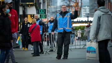 Rotterdam (Netherlands), 14/12/2020.- An officer of BOAs (extraordinary investigation officers) directs a shopper in the Koopgoot, Rotterdam, The Netherlands, 14 December 2020. In efforts to put an end to the sharp rise in the number of new corona infecti