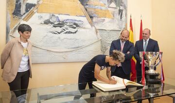 La jugadora rojiblanca Amanda Sampedro firma en el libro de visitas de la Comunidad de Madrid. 