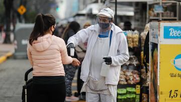 AME3622. BUENOS AIRES (ARGENTINA), 20/07/2020.- Un hombre toma la temperatura al ingreso a una feria de alimentos este lunes el primer día de la flexibilización de la cuarentena obligatoria por el COVID-19 en Buenos Aires (Argentina). La ciudad de Buenos Aires y su populosa área metropolitana (AMBA), junto a otras localidades con alta circulación de coronavirus, entraron este lunes en una etapa de la cuarentena más flexible, que contempla la apertura progresiva de actividades comerciales y habilita las salidas recreativas, todo sujeto a protocolos. EFE/Juan Ignacio Roncoroni
