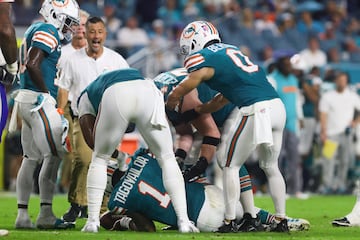 Tagovailoa (1) is checked on by teammates after an injury against the Buffalo Bills during the third quarter at Hard Rock Stadium.