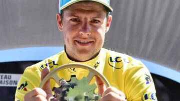 Winner of the Criterium du Dauphine 2017 Denmark's Jakob Fuglsang poses with his trophy as he celebrates his overall leader yellow jersey on the podium at the end of the 115 km eighth and last stage of the 69th edition of the Criterium du Dauphine cycling race on June 11, 2017 between Albertville and the Plateau de Solaison in Brison, French Alps. / AFP PHOTO / PHILIPPE LOPEZ