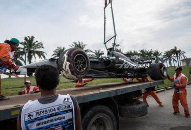 El coche de Romain Grosjean, de la escudería Haas F1, es retirado de la pista por los operarios del circuito de Sepang.