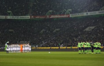 Los jugadores del Borussia Monchengladbach y del Wolfsburgo guardan un minuto de silencio en memoria de las víctimas del atentado al mercado navideño de Berlín.