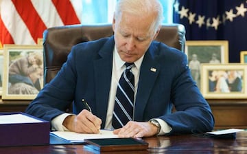 US President Joe Biden signs the American Rescue Plan on March 11, 2021, in the Oval Office of the White House in Washington, DC. - Biden signed the $1.9 trillion economic stimulus bill and will give a national address urging "hope" on the first anniversa