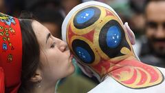 Una aficionada besa la cabeza de un hincha que se pint&oacute; el logo del Mundial 2018 en la cabeza.