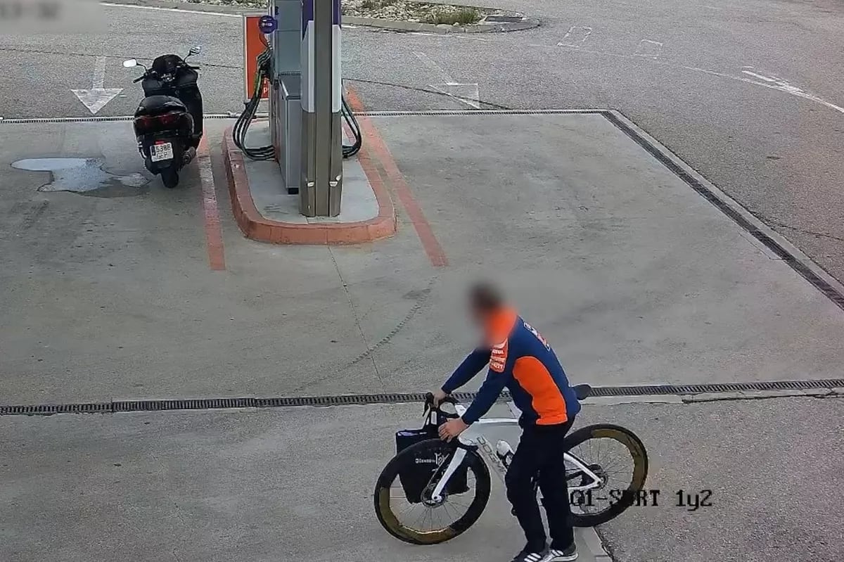 El hombre, vestido de KTM, con la bicicleta robada, en una gasolinera cercana al Circuito Ricardo Tormo de Valencia.