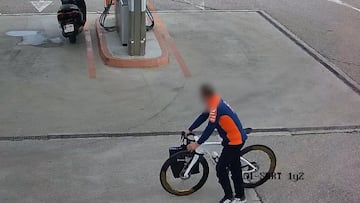 El hombre, vestido de KTM, con la bicicleta robada, en una gasolinera cercana al Circuito Ricardo Tormo de Valencia.