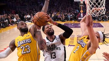 LOS ANGELES, CA - DECEMBER 25: JaVale McGee #7 and LeBron James #23 of the Los Angeles Lakers defend a shot by Paul George #13 of the Los Angeles Clippers in the second half of the game at Staples Center on December 25, 2019 in Los Angeles, California. NO