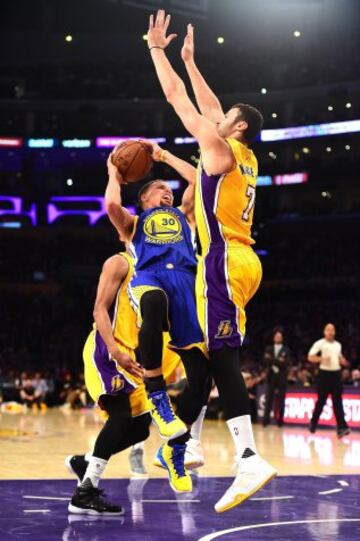 Stephen Curry trata de anotar ante la defensa de Larry Nance Jr..