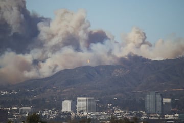 An aircraft flies to drop fire retardant over the area of a wildfire burning near Pacific Palisades on the west side of Los Angeles during a weather driven windstorm, in Los Angeles, California, January 7, 2025.  REUTERS/Daniel Cole