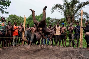 Dos miembros del grupo de lucha Soft Ground Wrestling pelean en un ring improvisado con postes de bambú y cuerdas en un campamento en Mukono (Uganda). Soft Ground Wrestling tiene 200 miembros, tanto hombres como mujeres, que están causando sensación en YouTube mientras sueñan con convertirse en luchadores profesionales.