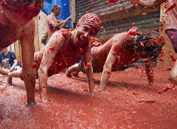 Revellers covered in tomato pulp take part in the annual "Tomatina" festival in the eastern town of Bunol, on August 30, 2017.
The iconic fiesta -- which celebrates its 72nd anniversary and is billed at "the world's biggest food fight" -- has become a major draw for foreigners, in particular from Britain, Japan and the United States. / AFP PHOTO / JAIME REINA