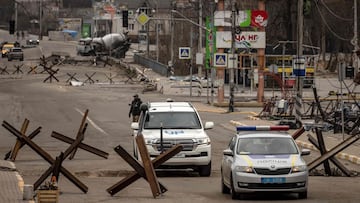 EDITORS NOTE: Graphic content / A UN and a police car ride in Bucha, on the outskirts of Kyiv, on April 13, 2022, amid Russia's military invasion launched on Ukraine. - A visit by the International Criminal Court's chief prosecutor to Bucha -- the Kyiv suburb now synonymous with scores of atrocities against civilians discovered in areas abandoned by Russian forces -- came as the new front of the war shifts eastward, with new allegations of crimes inflicted on locals. (Photo by FADEL SENNA / AFP)
