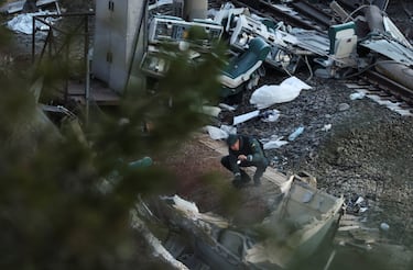 Un miembro de la Guardia Civil española busca con su linterna entre los restos de un tren involucrado en el accidente, en el lugar del descarrilamiento mortal de dos trenes de alta velocidad cerca de Adamuz.