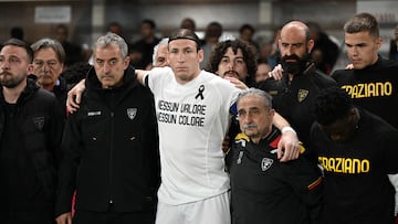 Federico Baschirotto, capitán del Lecce, junto al staff técnico durante el minuto de silencio por Graziano Fiorita