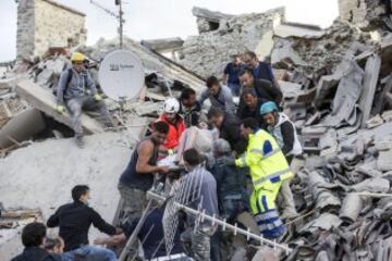 ITA14 AMATRICE (ITALIA) 24/08/2016.- Una mujer herida es rescatada de entre los escombros de un edificio en Amatrice, en el centro de Italia, hoy, 24 de agosto de 2016. Al menos 19 personas han fallecido y hay decenas de heridos tras el terremoto de 6 grados en la escala Richter que ha sacudido el centro de Italia esta madrugada, según informó la televisión pública RAI. EFE/Massimo Percossi