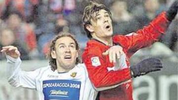 <b>LUCHA. </b>Milito y Milosevic pugnan por alto para hacerse con el control del balón.